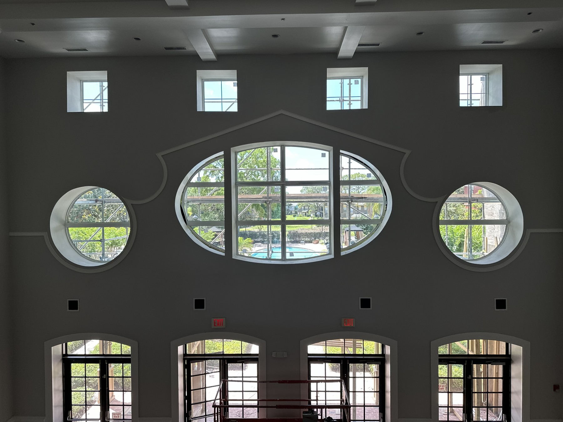 Grand interior with round, oval, and arched glazing overlooking a pool