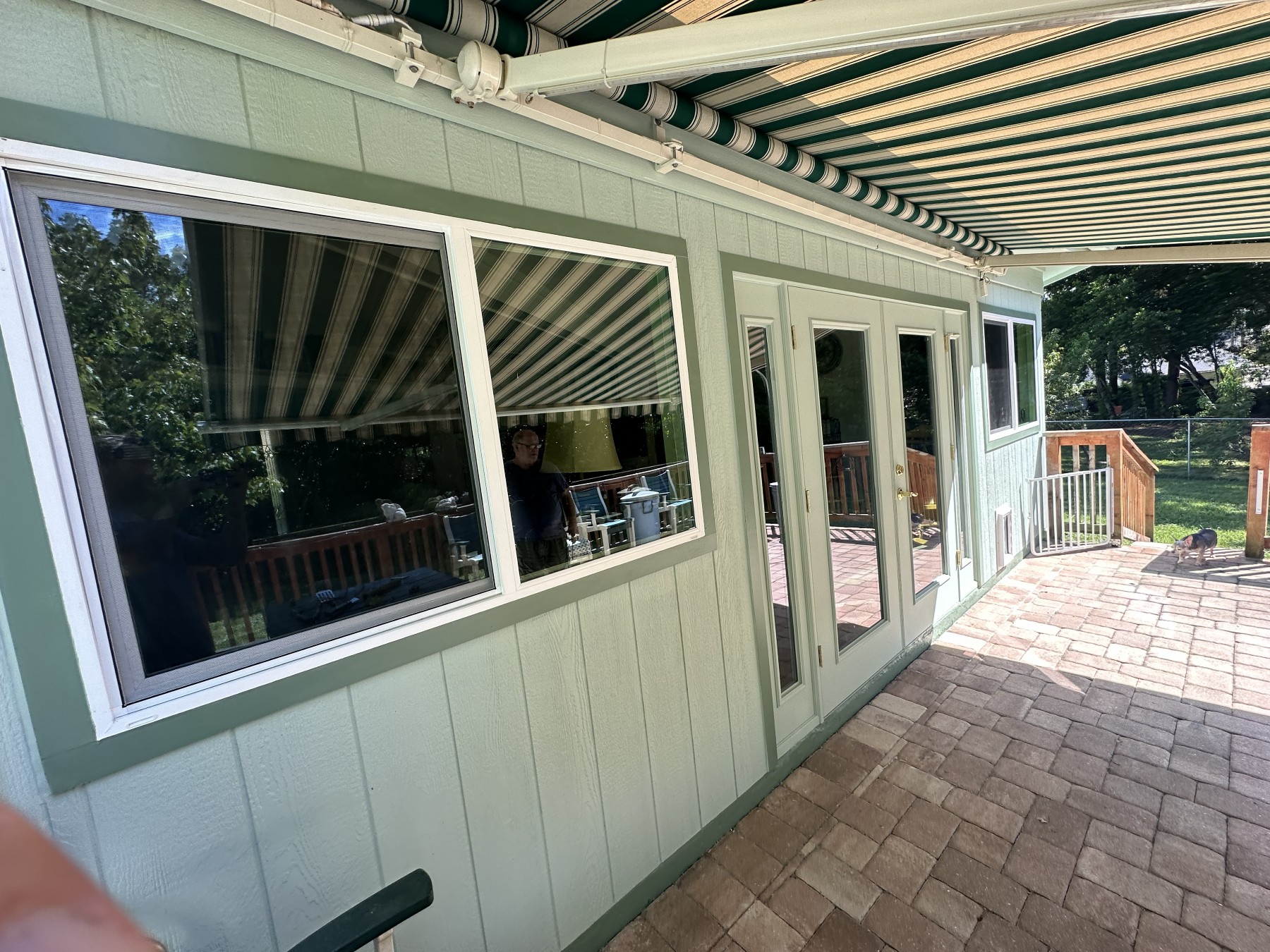 After: new white French doors and flanking windows under the awning