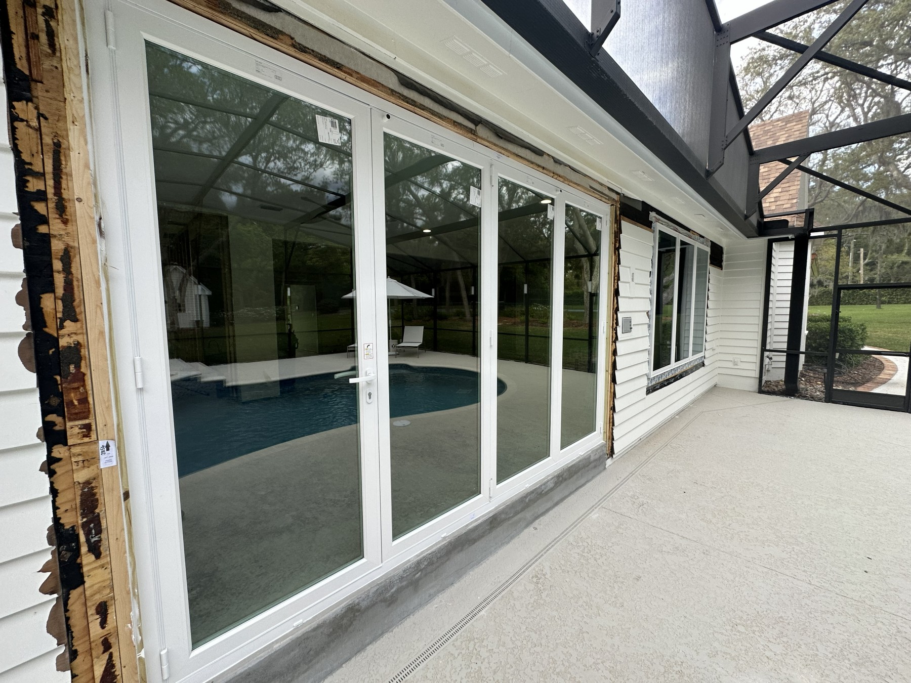 After: four-panel folding glass wall opening onto the pool deck