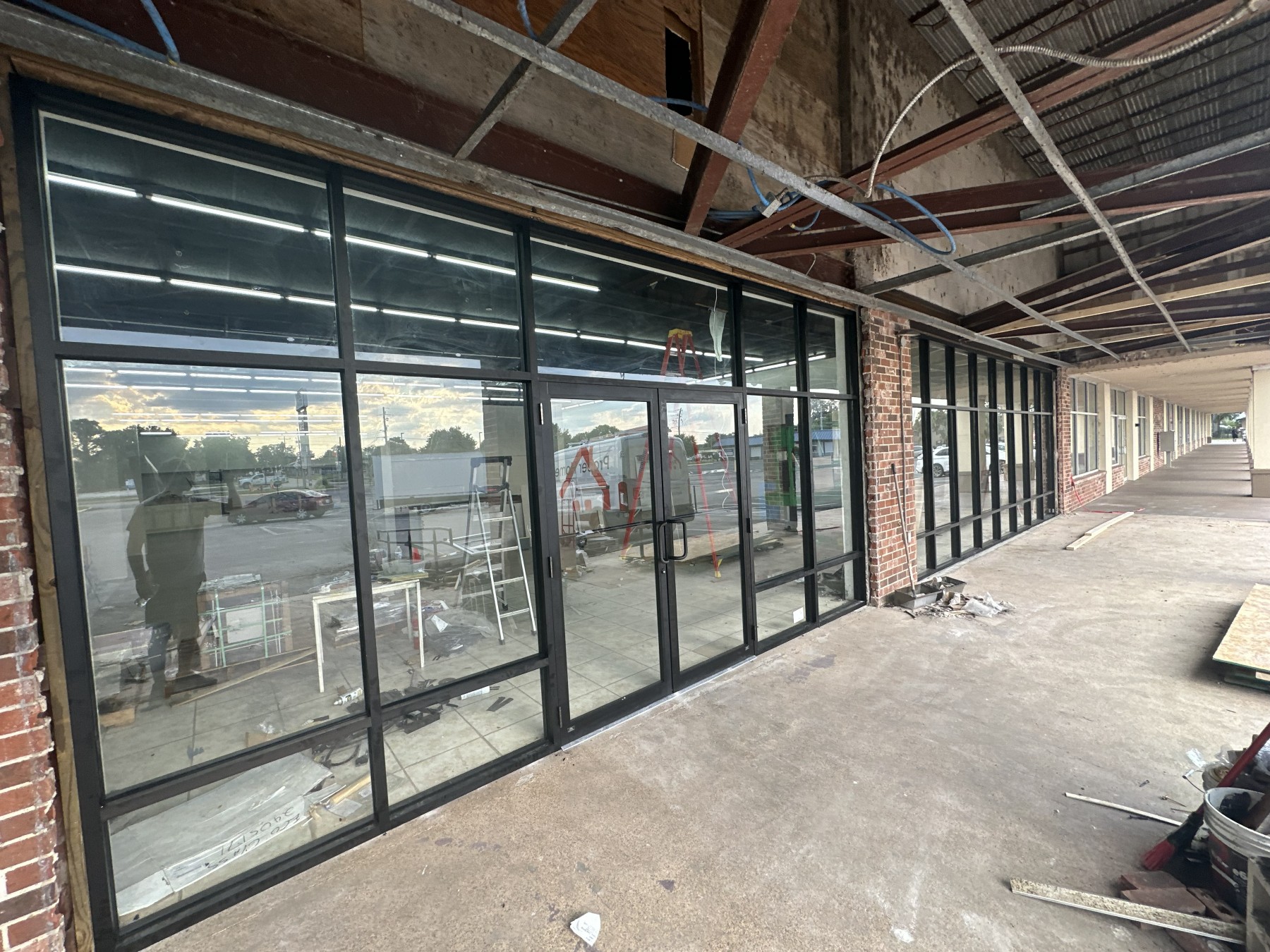Full-height black-framed storefront glazing and entry doors on a commercial retail unit