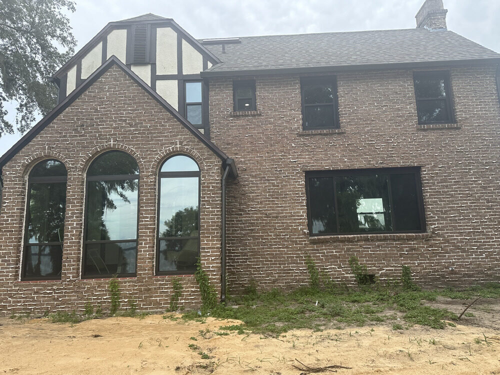 After: matching black-frame arched windows across the facade